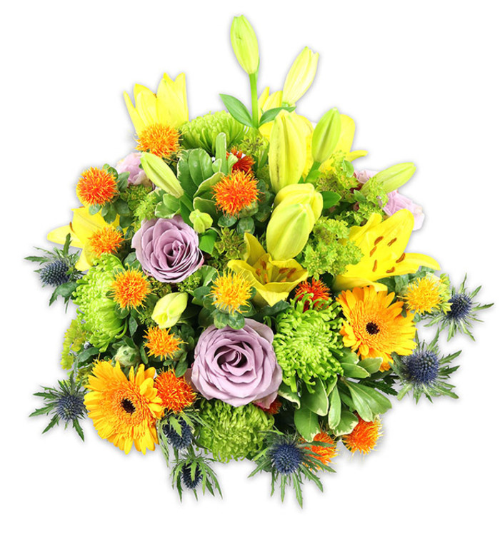 A dense, carefully balanced floral composition presented on a crisp white background, this bouquet blends warm yellows and oranges with cool lavender and blue for a lively yet sophisticated statement. Several yellow Asiatic lilies command attention, some fully opened to reveal their speckled throats and pollen-bearing stamens, while others remain as vertical buds, lending height and a sense of hopeful unfolding. Two pale lavender roses sit near the heart of the arrangement, their soft, fragrant petals spiralling inward to form a calm focal point amid the energetic colours. Bright orange Gerberas offer broad, flat faces and dark centres that read like small suns, and abundant lime-green button chrysanthemums create textured, ruffled mounds that fill and cushion the overall shape. Small, spherical orange-yellow accent blooms appear throughout, their spiky textures adding playful punctuation, while several indigo-blue sea thistles (Eryngium) with sharp, architectural bracts rise from the edges and lower thirds, providing an arresting cool contrast. Mixed foliage-ranging from smooth, glossy leaves to more delicate green fillers-establishes depth and frames each bloom so the eye travels easily across the bouquet. The image evokes late-spring warmth and is perfect for a celebratory centrepiece, a heartfelt thank-you, or a comforting sympathy tribute for families in and around Whitechapel or Stepney Way. Presented as if by a local floral studio, the arrangement speaks of seasonal freshness, tactile contrasts, and a design sensibility attuned to the East London neighbourhood it might brighten.